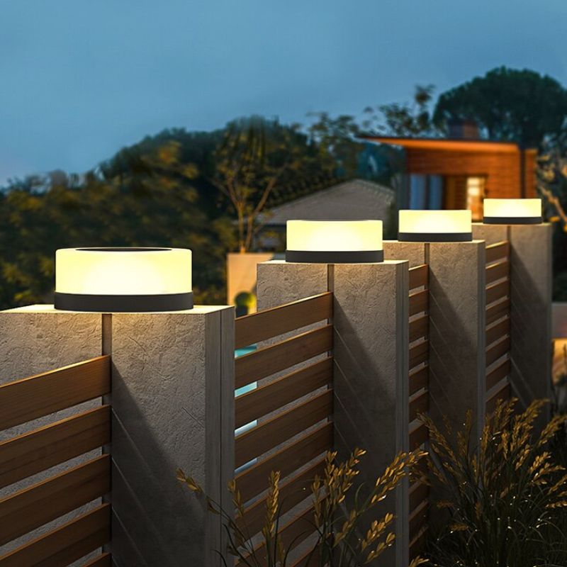 Lampe solaire cylindre design allumée sur pilier