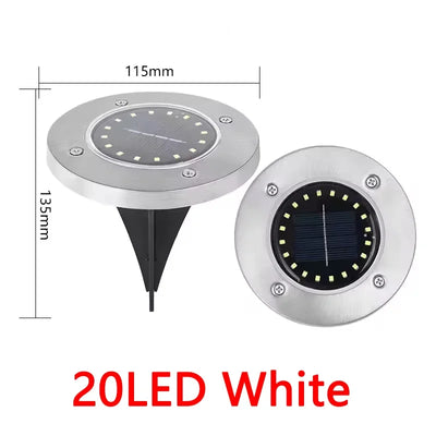 Lampe solaire disque enterrée éclairant un jardin la nuit
