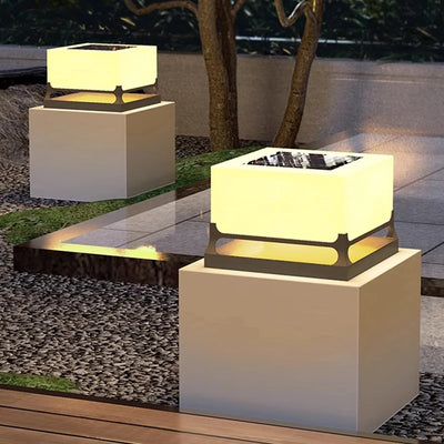 Lampe solaire cube blanc chaud sur un mur extérieur