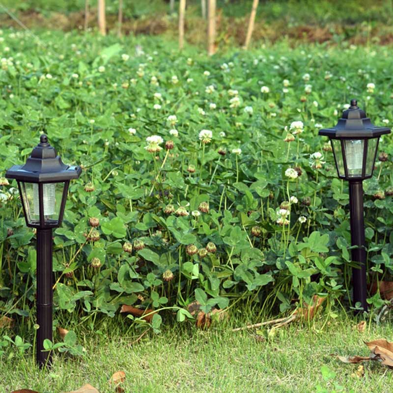 Piquet solaire balise chapeau pointu noir installé dans une allée de jardin