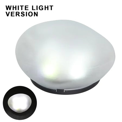 Lampe solaire galet posée dans un massif