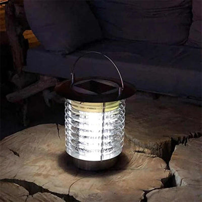 Lampe solaire anti-moustique posée sur une table de terrasse