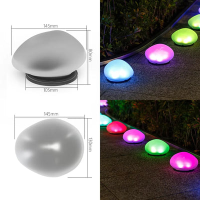 Lampe solaire galet éclairant un jardin la nuit