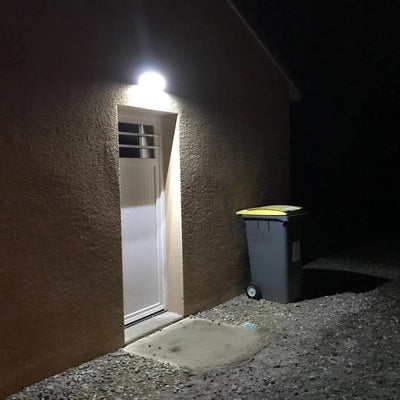 Applique solaire 1000lm éclairant une porte d'entrée la nuit