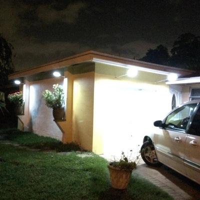 Applique solaire murale avec mât éclairant un carport la nuit