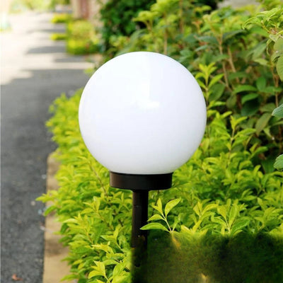 Boule lumineuse solaire dans une haie verte de jour