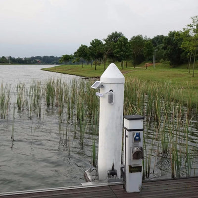 Globe solaire installé sur un poteau au bord d'un lac