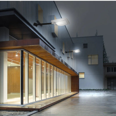 Lampadaire solaire blanc mât mur bâtiment nuit