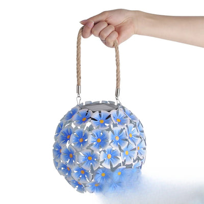 Lampion solaire fleur coloris bleu tenu à la main