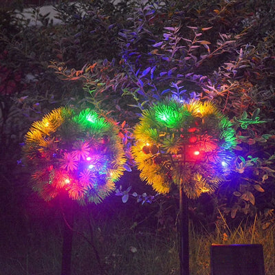 Lampe solaire pomme de pin couleurs vives dans le jardin la nuit