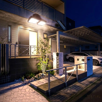 Projecteur solaire double orientable éclairant une entrée de maison