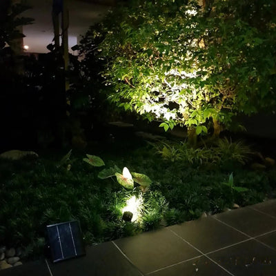 Spot solaire design éclairant un jardin la nuit