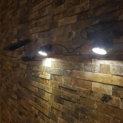 Spot solaire design éclairant un mur en pierre